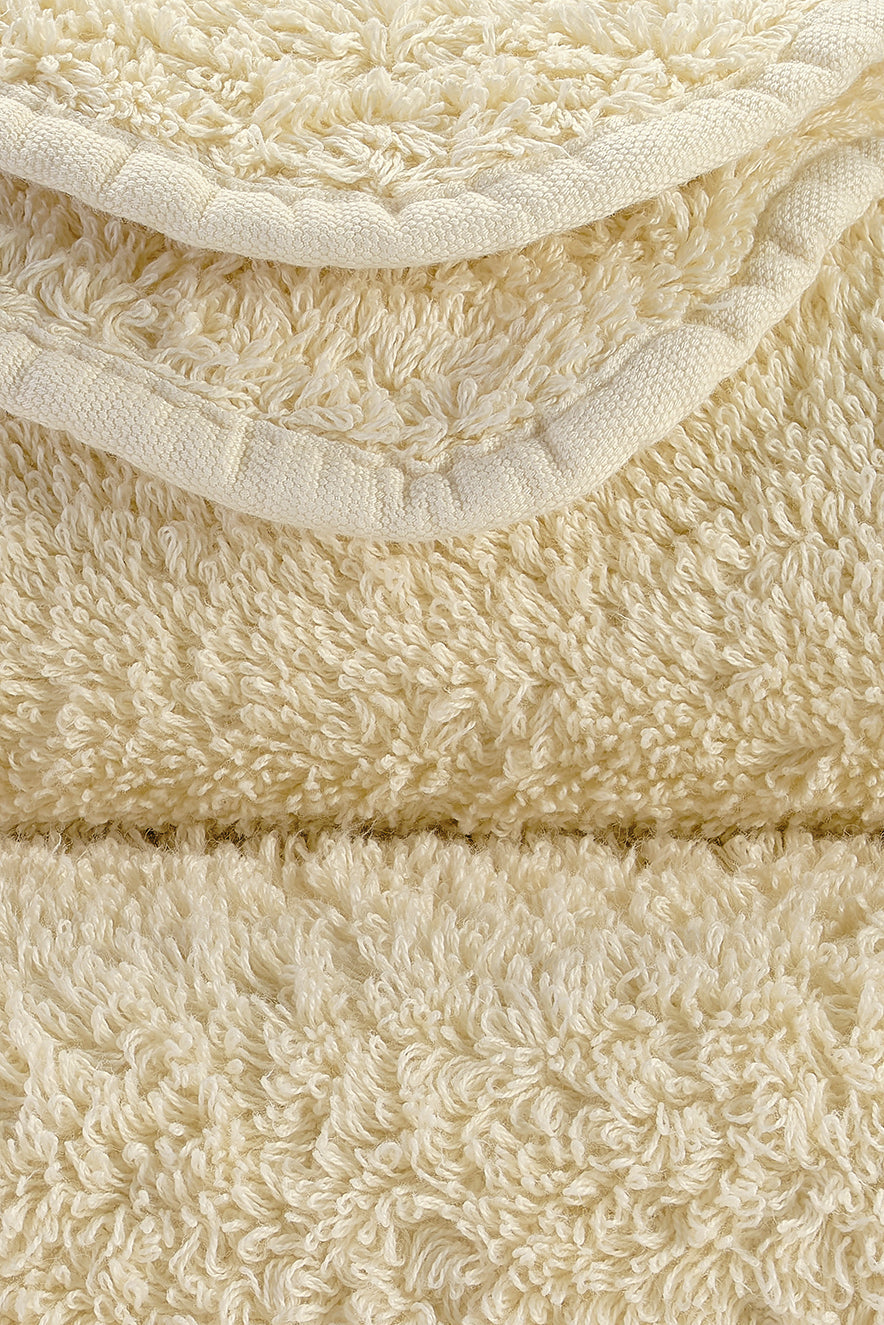 Close-up of cream-coloured terry towels with a dense, soft texture.