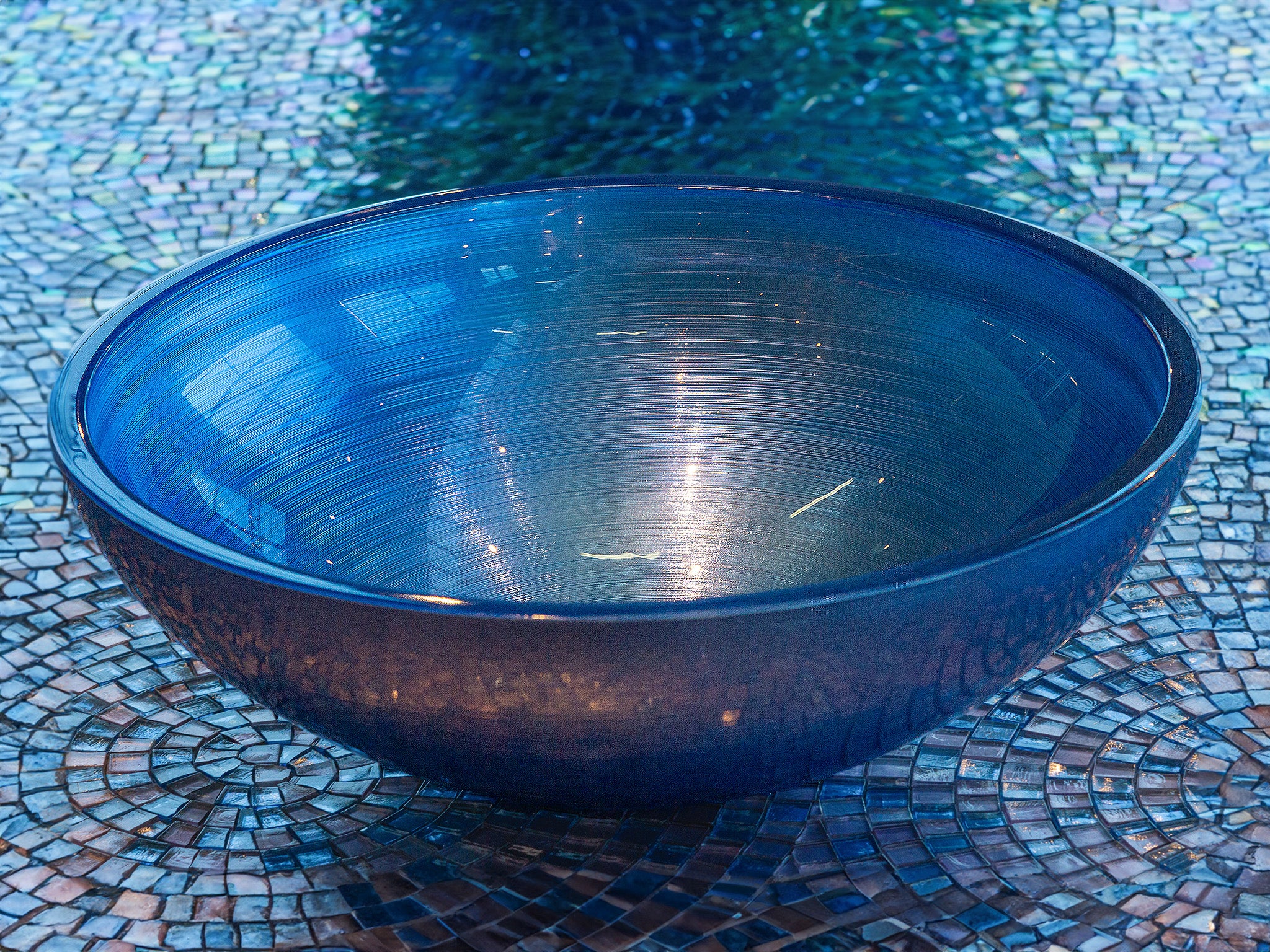 A jewel for your bathroom: the "Doh" countertop basin in glass, round and in Blue. A perfect designer basin with a fine fluted texture. Italian craftsmanship gives rise to this sparkling coloured glass basin. Matching mosaics are available on request as a surround. Now in the Tiamont shop. 
