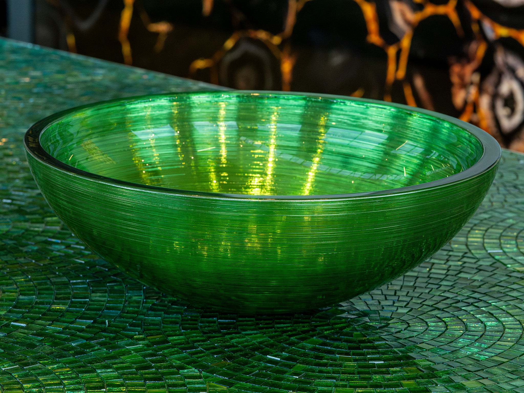 Round premium glass basin in emerald green, a jewel for your bathroom. Ribbed interior finish, Italian craftsmanship by Sicis, available in the Tiamont online boutique for refined bathroom furniture.